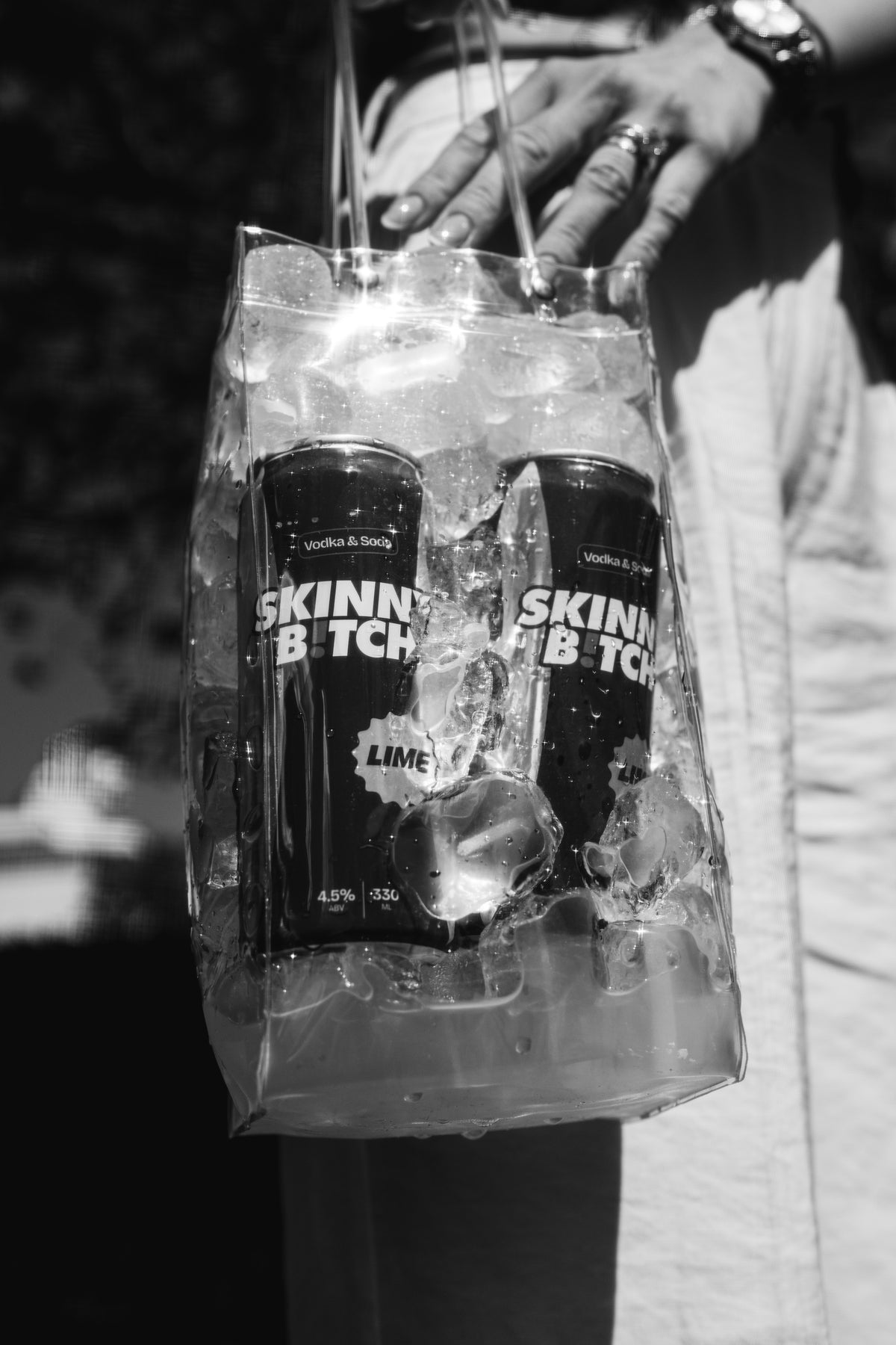 Three friends in SKINNY B!TCH tees with cans at a night event